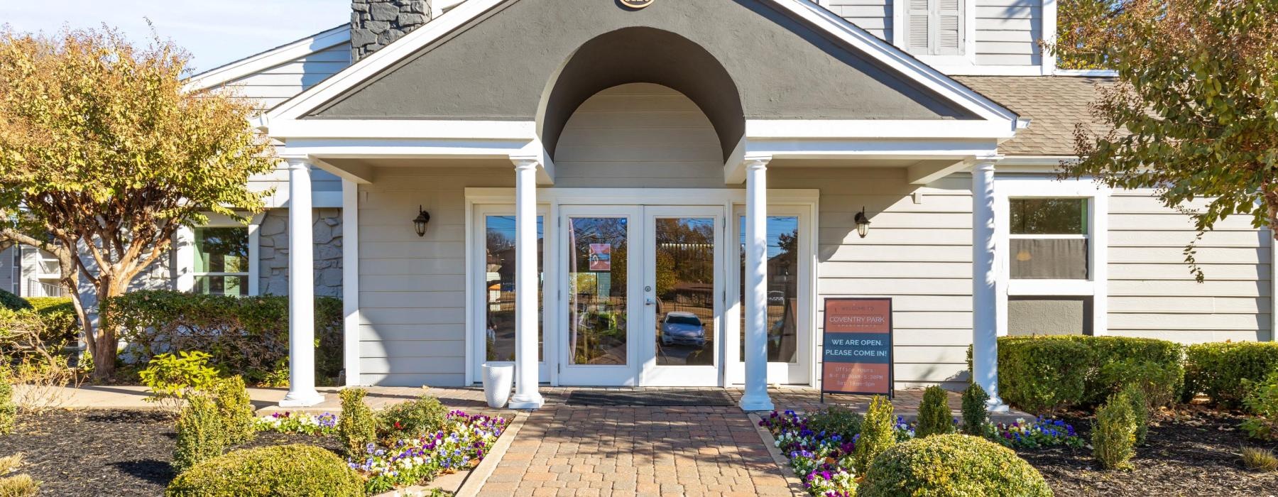 a white house with a brick driveway