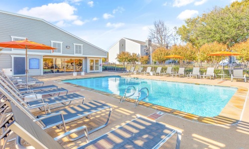 a swimming pool with lounge chairs around it